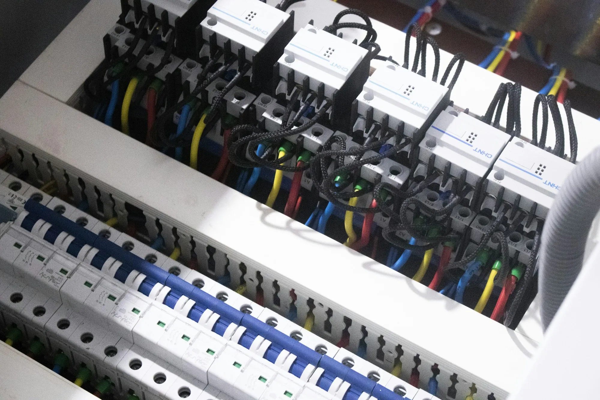 Rows of circuit breakers and wiring inside an open electrical panel